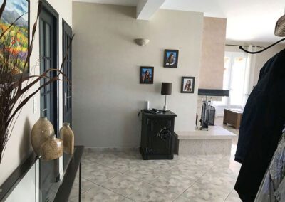 Vue 3D entrée dans séjour : création d'un sas dressing et ouverture avec une verrière atelier sur la cuisine