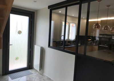 Entrée lumineuse après travaux : porte d'entrée vitrée en verre dépoli et incrustations de verre "fusing", verrière atelier ouverte sur la cuisine